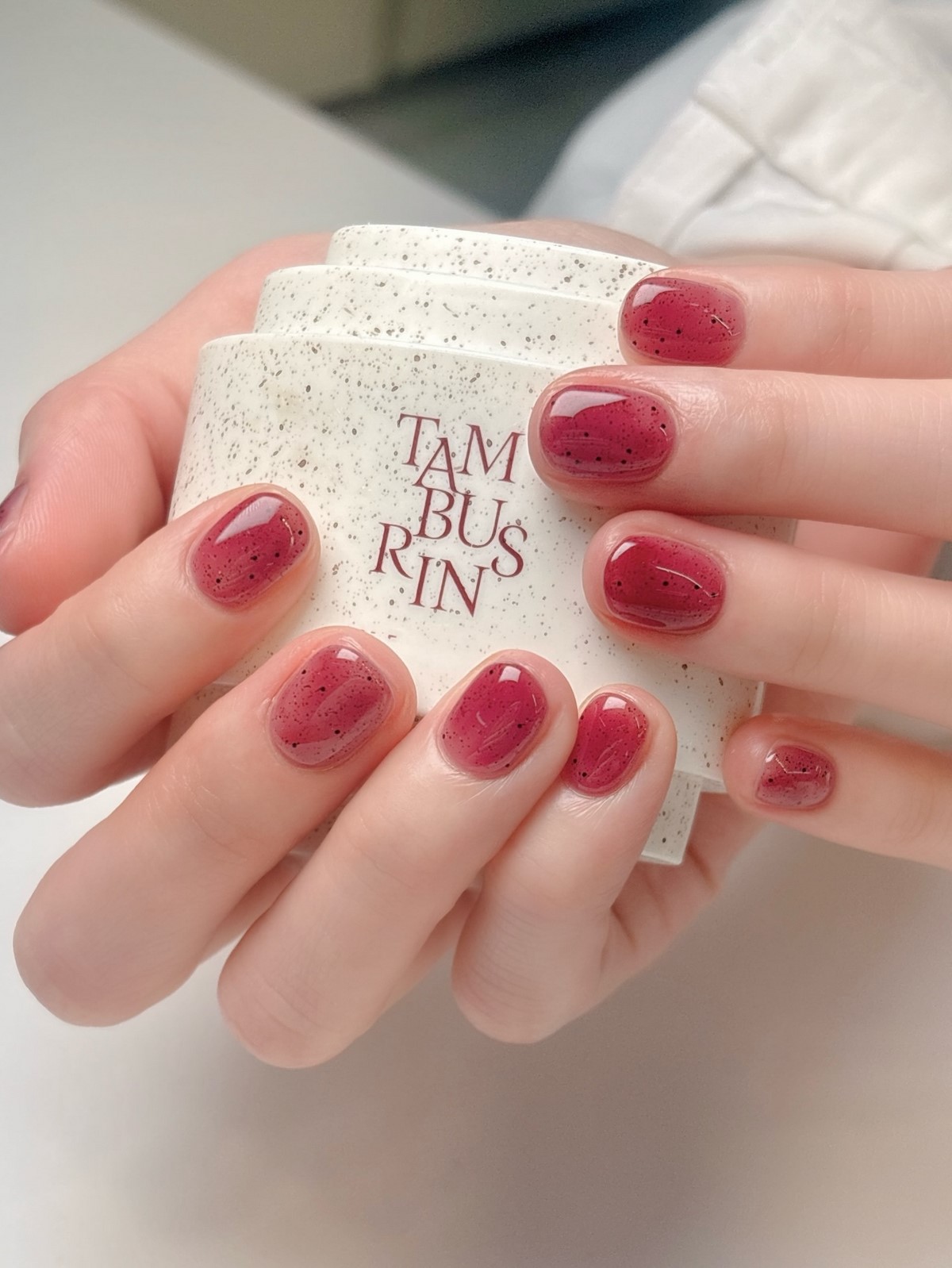 Ягодно-малиновый jelly-маникюр с мелкими темными вкраплениями на коротких ногтях
